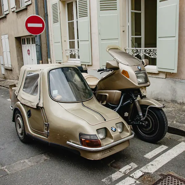 A BMW motorcycle and sidecar fill a parking space in France.