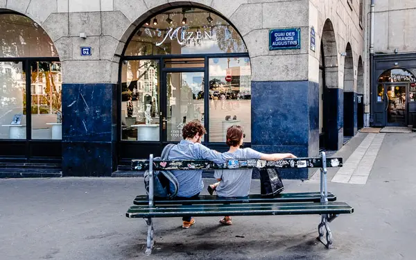 A man and a woman share a bench in the 6th arrondissement of Paris.