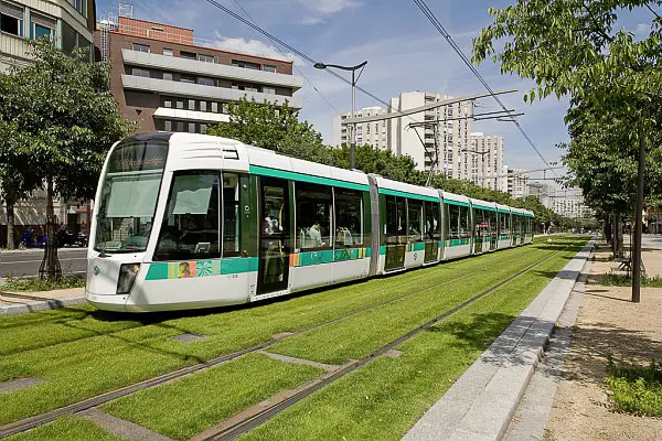 A Line 3 Paris tram follows a grass right of way alongside the Boulevard Kellerman in the 13th arrondissement.
