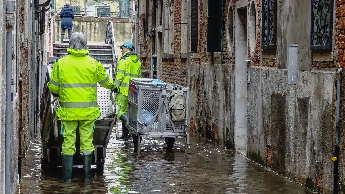 Spazzini in Venice, Italy with garbage and recycling carts during an acqua alta flood tide.