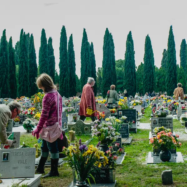 Family members tend graves at the island cemetery of San Michele in Venice, Italy.