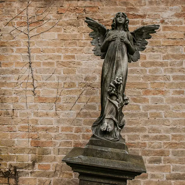 A statue of an angel stands above the grave of Emmy Amelm Mowicki, a child who died in 1908.