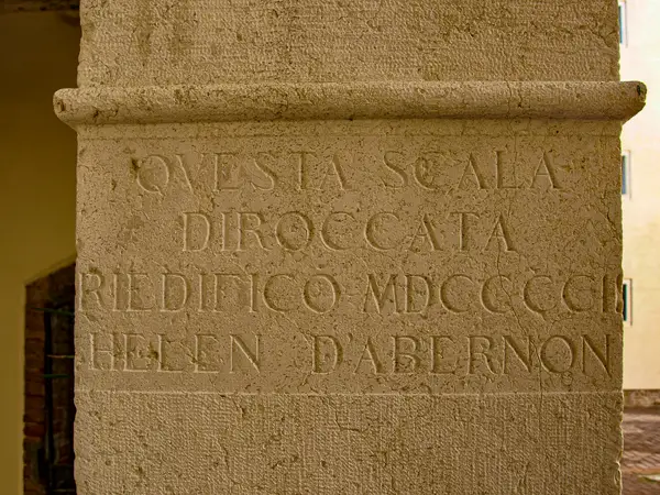 An inscription on a column at Ca' Giustianian in Venice honors Helen D'Aberdon, a British expatriate who raised funds to restore the palazzo's historic staircase.