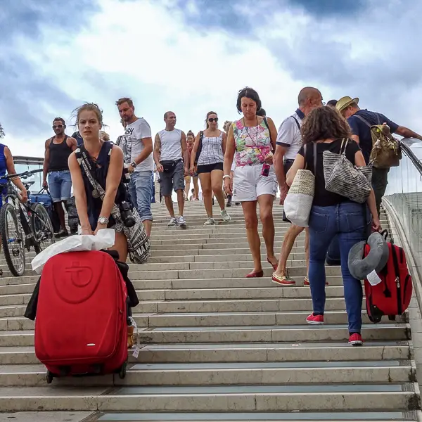 A tourist hauls her heavy suitcase up the steps on the Ponte della Costituzione (a.k.a. the Calatrava Bridge).