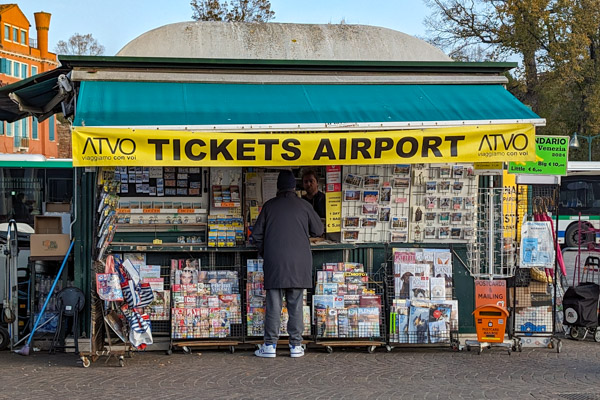 Newsstand in Piazzale Roma, Venice, with ATVO ticket banner.