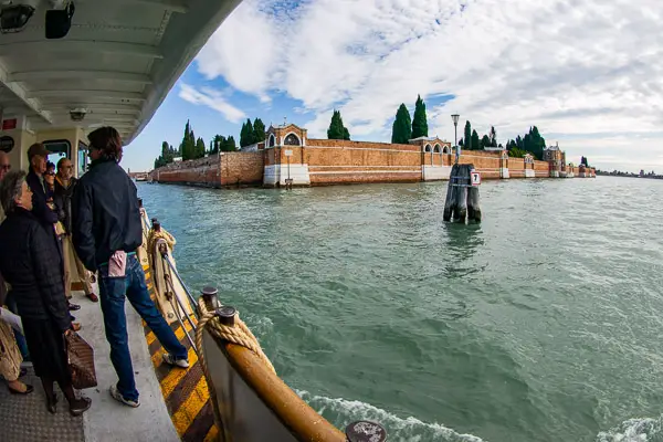 An ACTV water bus approaches the island cemetery of San Michele in Venice, Italy.