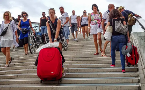 A tourist hauls her heavy suitcase up the steps on the Ponte della Costituzione (a.k.a. the Calatrava Bridge).