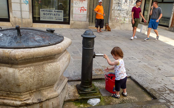 Little girl at water fountain in Venice, Italy
